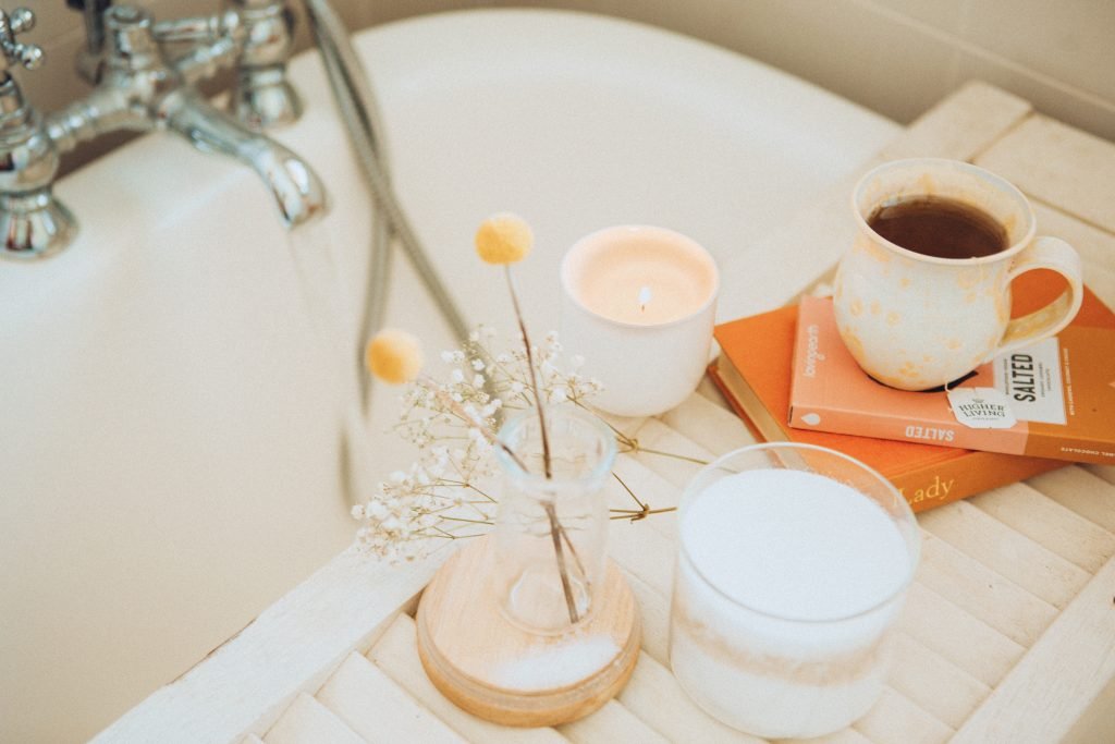 Bath with coffee cup, book and flowers