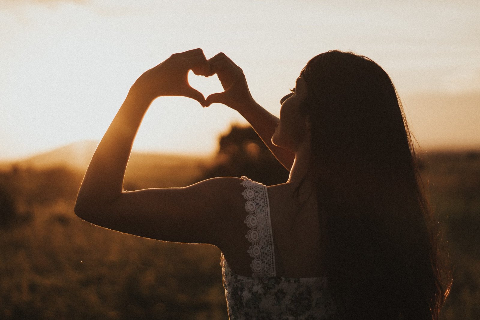 Women holding her hands in a heart shape to symbolise self care